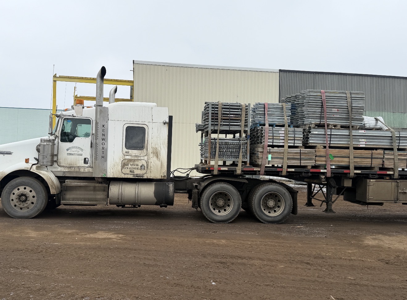 53-foot flat-deck trailer loaded with structural steel and scaffolding