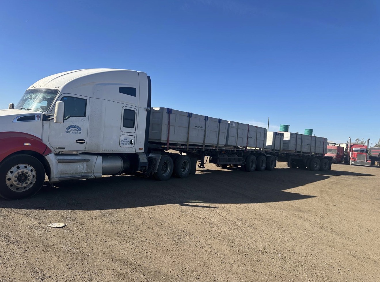 White Kenworth with Super B-train flat-deck loaded with industrial tanks